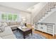 Inviting living room boasts hardwood floors, a staircase, and stylish console with convenient storage at 1449 Braewood Ave, Highlands Ranch, CO 80129