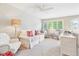 Bright and spacious living room features comfortable seating, ample light from large windows, and a ceiling fan at 1449 Braewood Ave, Highlands Ranch, CO 80129