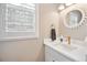 Stylish powder room features a decorative mirror, modern fixtures, and ample natural light at 1449 Braewood Ave, Highlands Ranch, CO 80129