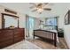 Comfortable bedroom boasts a ceiling fan and soft, natural light from the windows at 1055 Ponderosa Cir, Longmont, CO 80504