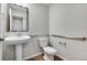 Accessible bathroom featuring a pedestal sink, toilet, and grab bars for safety at 16798 W 94Th Way, Arvada, CO 80007