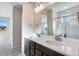 Well lit bathroom featuring a double vanity, large mirror, and a glass-enclosed shower at 16798 W 94Th Way, Arvada, CO 80007
