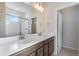 Bright bathroom featuring a double vanity, large mirror, and a glass-enclosed shower at 16798 W 94Th Way, Arvada, CO 80007