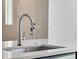 Close-up of a kitchen sink, showcasing a modern faucet and white countertops at 16798 W 94Th Way, Arvada, CO 80007