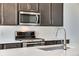 Modern kitchen featuring stainless steel appliances, gray cabinets, and a stylish gooseneck faucet at 16798 W 94Th Way, Arvada, CO 80007