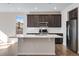 Kitchen with large island, quartz countertop, stainless steel appliances, dark wood cabinets, and hardwood floors at 16798 W 94Th Way, Arvada, CO 80007