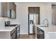 Kitchen featuring stainless steel appliances, dark cabinets, quartz countertops, and white subway tile backsplash at 16798 W 94Th Way, Arvada, CO 80007