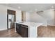 Kitchen island features quartz countertops, stainless steel appliances, dark cabinets, and hardwood floors at 16798 W 94Th Way, Arvada, CO 80007