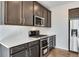 Close up of kitchen featuring stainless steel appliances, dark cabinets, quartz countertops, and white subway tile backsplash at 16798 W 94Th Way, Arvada, CO 80007