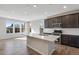 Open concept kitchen area features large windows, dark cabinets, stainless steel appliances, and hardwood floors at 16798 W 94Th Way, Arvada, CO 80007