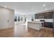 Bright kitchen and dining area with large windows, dark cabinets, stainless steel appliances, and hardwood floors at 16798 W 94Th Way, Arvada, CO 80007