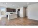 Modern kitchen features a large island with quartz countertop, stainless steel appliances, and dark wood cabinets at 16798 W 94Th Way, Arvada, CO 80007