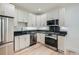 Modern kitchen with stainless steel appliances, white cabinets, and stone countertops at 715 W 7Th Ave, Denver, CO 80204