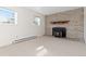 Bright living room featuring a charming brick fireplace and large windows at 3194 W 9Th Avenue Pl, Broomfield, CO 80020
