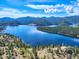 Overhead view of a lake surrounded by lush green forests and rolling mountains under a bright sky at 439 Ronnie Rd, Golden, CO 80403