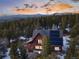 Mountain home nestled among lush trees featuring solar panels, mountain views in the background, and a private setting at 439 Ronnie Rd, Golden, CO 80403