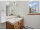 Well-lit bathroom featuring a vanity with tile countertop and a window with peaceful outdoor views at 439 Ronnie Rd, Golden, CO 80403