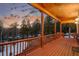 Covered deck with wooded views and red wood flooring and rails at 439 Ronnie Rd, Golden, CO 80403