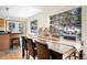 Dining room showcasing a large wooden table, views of a snowy wooded yard, and adjacent breakfast bar at 439 Ronnie Rd, Golden, CO 80403