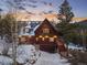 Mountain chalet with an attached garage, steps to the deck, and snow covered landscape at 439 Ronnie Rd, Golden, CO 80403