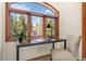An arched window with a wooden frame provides views of the mountains from a desk at 439 Ronnie Rd, Golden, CO 80403