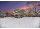 Backyard featuring a wooden deck with patio furniture and a barbecue grill, all surrounded by a snow-covered yard at 5229 Nighthawk Pkwy, Brighton, CO 80601