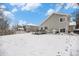 Backyard featuring a wooden deck with patio furniture and a barbecue grill, all surrounded by a snow-covered yard at 5229 Nighthawk Pkwy, Brighton, CO 80601