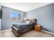 Comfortable bedroom features natural light from a large window and rustic wood furnishings at 5229 Nighthawk Pkwy, Brighton, CO 80601