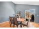 Dining area with wooden floors, a view to the backyard, and a modern table set at 5229 Nighthawk Pkwy, Brighton, CO 80601