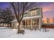 Charming two-story home featuring a welcoming front porch and two-car garage, surrounded by a snow-covered yard at 5229 Nighthawk Pkwy, Brighton, CO 80601