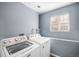 Well-lit laundry room with washer and dryer hookups and a large window at 5229 Nighthawk Pkwy, Brighton, CO 80601