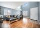Bright living room with hardwood floors, large windows, and comfortable seating under a high ceiling at 5229 Nighthawk Pkwy, Brighton, CO 80601