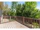 Outdoor deck with wood floor and brown railings and a tree-filled backyard at 12666 Davis St, Broomfield, CO 80020