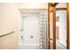 Bathroom with a shower-tub, a shower curtain, chrome fixtures, and access to the bedroom at 12579 Appaloosa Pl, Broomfield, CO 80020
