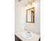 Bathroom vanity with a framed mirror, three-light fixture, and white sink basin at 12579 Appaloosa Pl, Broomfield, CO 80020