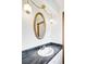 Charming bathroom with a vanity, marble countertop, decorative lighting and oval mirror at 12579 Appaloosa Pl, Broomfield, CO 80020