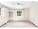Bright bedroom with white carpet, a ceiling fan, windows, and open shelving for storage at 12579 Appaloosa Pl, Broomfield, CO 80020