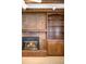 Living room fireplace with brick hearth, built-ins and decorative mantel at 12579 Appaloosa Pl, Broomfield, CO 80020