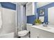 Bathroom features a blue wall and a shower and tub combination with updated sink and vanity with a white cabinet at 4785 Aberdeen Ave, Highlands Ranch, CO 80126