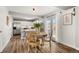 Bright dining area with wood floors and views of the modern kitchen through an open doorway at 4785 Aberdeen Ave, Highlands Ranch, CO 80126