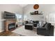 Bright living room featuring high ceilings, a cozy fireplace, and ample natural light at 4785 Aberdeen Ave, Highlands Ranch, CO 80126