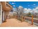 Spacious wooden back deck featuring black railings, with neighborhood views on a sunny day at 5668 S Rifle Ct, Centennial, CO 80015