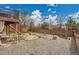 Large backyard with gravel area, wooden fence, and a glimpse of the surrounding greenery at 5668 S Rifle Ct, Centennial, CO 80015