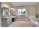 Primary bathroom featuring double vanity with a bathtub and a large window at 5668 S Rifle Ct, Centennial, CO 80015