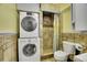 Unique bathroom with stacked washer dryer, shower and toilet with decorative tiled walls at 5668 S Rifle Ct, Centennial, CO 80015
