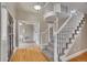Bright foyer featuring hardwood floors, a staircase with white railings, and an open view to the office space at 5668 S Rifle Ct, Centennial, CO 80015
