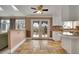 Bright kitchen boasts stone floors, white cabinets, and double doors to the outdoor deck at 5668 S Rifle Ct, Centennial, CO 80015