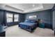This bedroom has a tray ceiling, neutral carpet, and coordinating blue walls, bedding, and furniture at 8109 Mount Ouray Rd, Littleton, CO 80125
