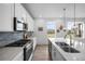 Well-lit kitchen with stainless appliances, long countertops, and a center island with double sink at 8109 Mount Ouray Rd, Littleton, CO 80125