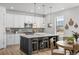Bright kitchen has an island with barstool seating and modern pendant lights for elegant style at 8109 Mount Ouray Rd, Littleton, CO 80125